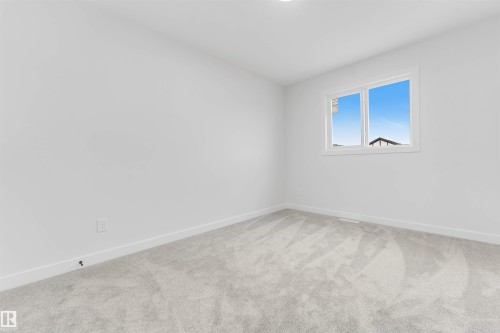 Neutral white walls with a contemporary window, soft gray carpeting, and white trim - 523 Robinson Blvd, Leduc, AB 