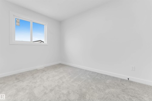 Neutral wall palette, window with white trim, and light-toned carpeting - 523 Robinson Blvd, Leduc, AB 