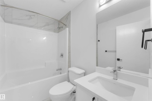 White integrated shower-over-tub with marble-look tile surround - 523 Robinson Blvd, Leduc, AB 
