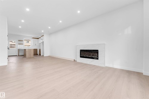 Open concept living area featuring wood-finish flooring and recessed lighting - 523 Robinson Blvd, Leduc, AB 