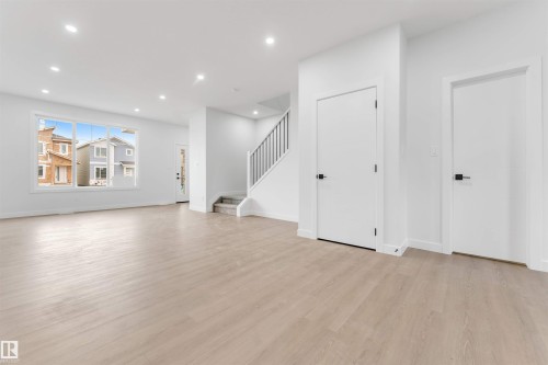 Recessed lighting, wood-finish flooring, white walls, and a staircase with carpeted treads - 523 Robinson Blvd, Leduc, AB 
