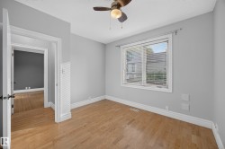 Wood-finish flooring, light grey wall paint, and a ceiling fan with integrated lighting - 