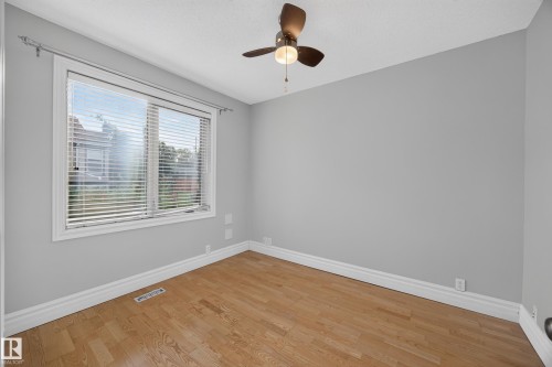 Hardwood flooring, light gray wall finishes, white trim, window with blinds, and a ceiling fan - 9615 75 Avenue Nw, Edmonton, AB 