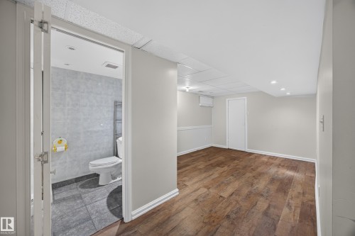 Wood-finish flooring, recessed lighting, and white baseboards - 9615 75 Avenue Nw, Edmonton, AB 