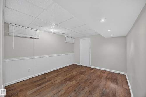 Wood-finish flooring with crisp white wainscoting and light gray walls - 9615 75 Avenue Nw, Edmonton, AB 
