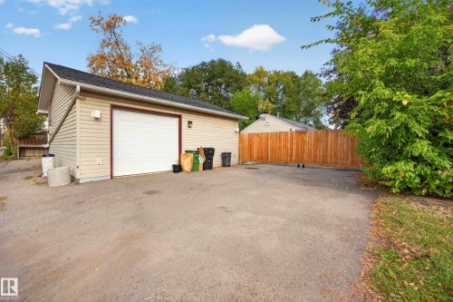 Detached garage with siding exterior, asphalt shingle roof, and a wood privacy fence - 9615 75 Avenue Nw, Edmonton, AB 