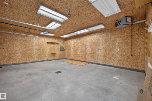 Concrete flooring, oriented strand board walls, integrated ceiling lighting, wall-mounted heater, and built-in shelving - 9615 75 Avenue Nw, Edmonton, AB 