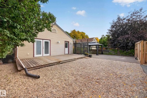 Rear exterior with a wooden deck, double glass-paned doors, and a detached gazebo - 9615 75 Avenue Nw, Edmonton, AB 