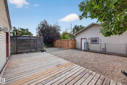 Expansive wood deck with a privacy screen, gravel hardscaping, and a detached structure with siding - 9615 75 Avenue Nw, Edmonton, AB 