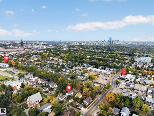 Aerial perspective showcasing an urban skyline in the background, residential areas with mature trees, commercial buildings, and paved roadways - 9615 75 Avenue Nw, Edmonton, AB 