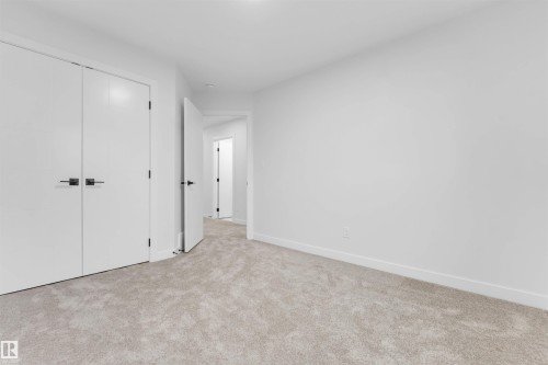 Wall-to-wall carpeting, white interior doors, and modern door hardware - 525 Robinson Blvd, Leduc, AB 