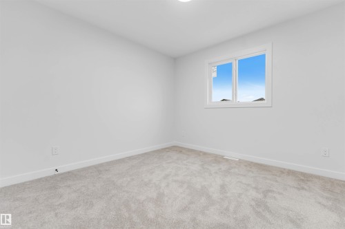 Neutral tone wall color, light-colored carpet flooring, white window frame, and recessed ceiling light - 525 Robinson Blvd, Leduc, AB 