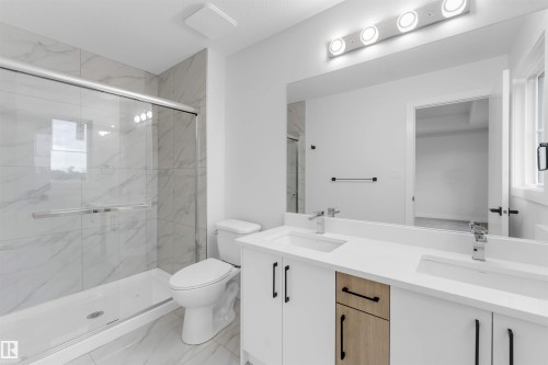 Dual vanity with white countertops, undermount sinks, and chrome faucets - 525 Robinson Blvd, Leduc, AB 