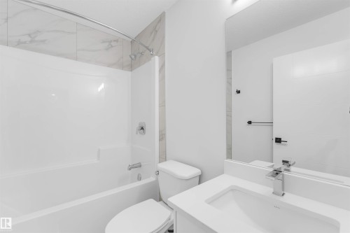 Full-size bathtub with a curved shower rod and tile surround, single vanity with integrated sink and chrome faucet, and a large wall-mounted mirror - 525 Robinson Blvd, Leduc, AB 