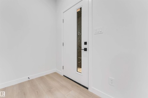 Entry door with vertical glass insert and matte black hardware - 525 Robinson Blvd, Leduc, AB 