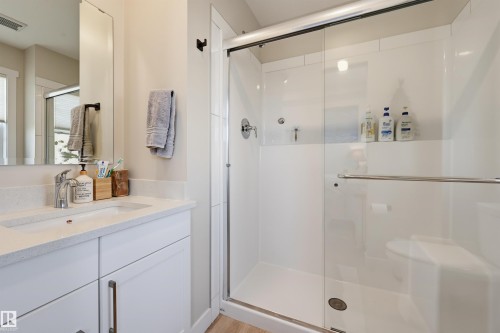 White vanity with a light-colored countertop, undermount sink, and chrome faucet - #3 150 Everitt Dr N, St. Albert, AB 