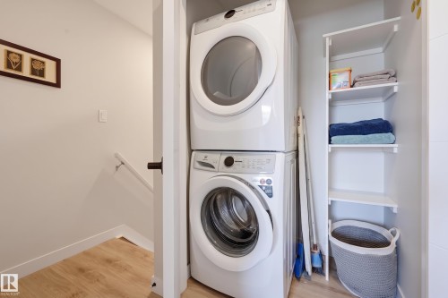 Stackable washer and dryer, built-in shelving, wood-finish flooring, and a handrail - #3 150 Everitt Dr N, St. Albert, AB 