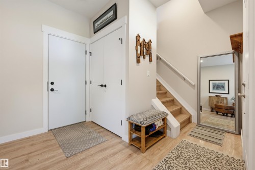 Light wood-finish flooring, white trim, and a staircase with a white handrail - #3 150 Everitt Dr N, St. Albert, AB 