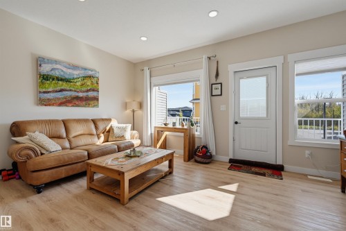 Recessed lighting, wood-finish flooring, white trim, and a patio door with an integrated window - #3 150 Everitt Dr N, St. Albert, AB 