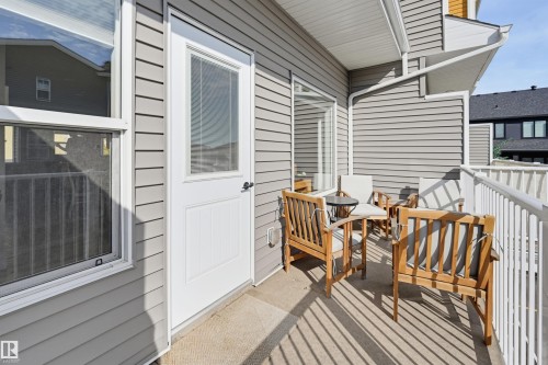 Private balcony featuring a white railing, gray siding, and an exterior door with integrated window - #3 150 Everitt Dr N, St. Albert, AB 