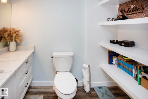 White vanity with dark hardware, white countertop, and wood-finish flooring - 8 Ash Crescent, St. Albert, AB 