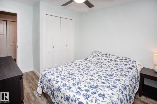 Wood-finish flooring, white bi-fold closet doors, and an overhead ceiling fan - 8 Ash Crescent, St. Albert, AB 