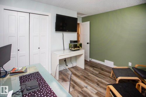 Wood-finish flooring, white panel bi-fold closet doors, and a solid interior door - 8 Ash Crescent, St. Albert, AB 