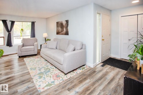 Wood-finish flooring, white walls, white trim, and a white front entry door with a sidelight - 8 Ash Crescent, St. Albert, AB 
