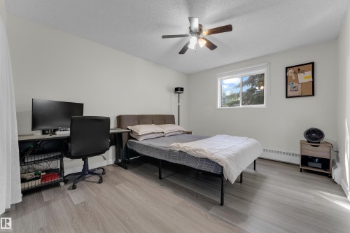 Neutral color palette, wood-finish flooring, ceiling fan, and window with natural light - #113 2508 50 St Nw, Edmonton, AB 