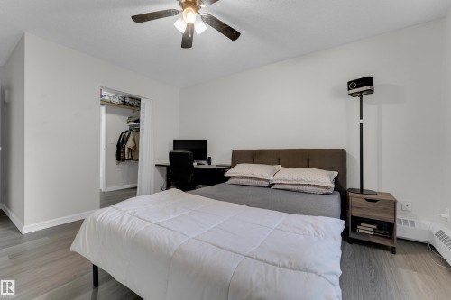 Recessed closet area, ceiling fan with integrated lighting, and wood-finish flooring - #113 2508 50 St Nw, Edmonton, AB 