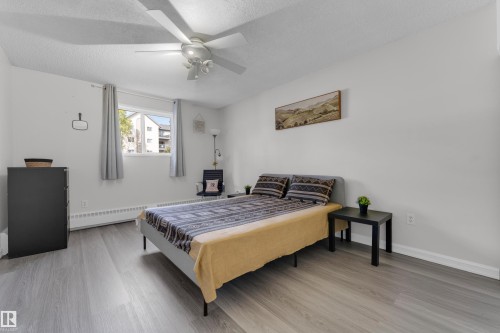 Recessed lighting, ceiling fan, wood-finish flooring, white walls, and a window with natural light - #113 2508 50 St Nw, Edmonton, AB 