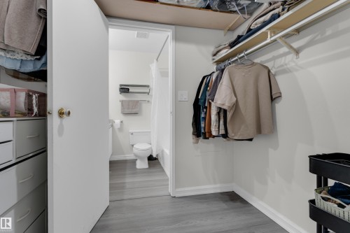 Walk-in closet with integrated shelving and hanging rod - #113 2508 50 St Nw, Edmonton, AB 