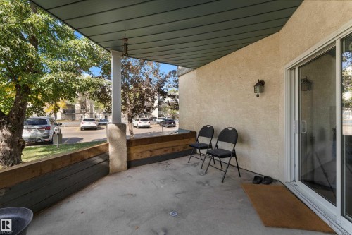 Covered patio featuring a concrete surface, stucco exterior, and a sliding glass door - #113 2508 50 St Nw, Edmonton, AB 