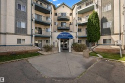 Multi-story building exterior with individual balconies, covered main entrance, and mature landscaping - 