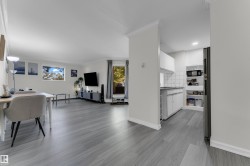 Open-concept living space with light wood-finish flooring, crown molding, and recessed lighting - 