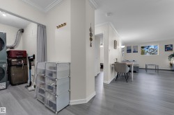 White walls with crown molding, light wood-finish flooring, and a window with exterior scenery - 