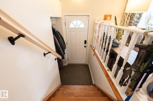 Wood-finish stairs with a natural wood-finish handrail and painted white balusters - 10972 157 Street Nw, Edmonton, AB 