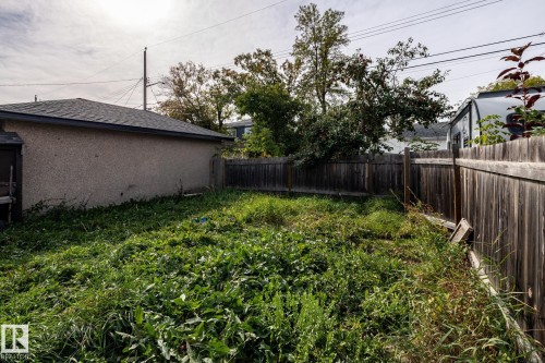Backyard space with wood fencing and an exterior building featuring a shingled roof - 10972 157 Street Nw, Edmonton, AB 