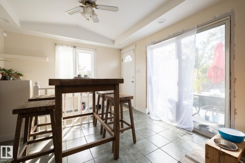 Tiled flooring throughout, featuring a glass sliding door, recessed lighting, and a ceiling fan fixture - 10972 157 Street Nw, Edmonton, AB 