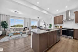 Open-concept living space featuring wood-finish flooring, recessed lighting, and large windows - 