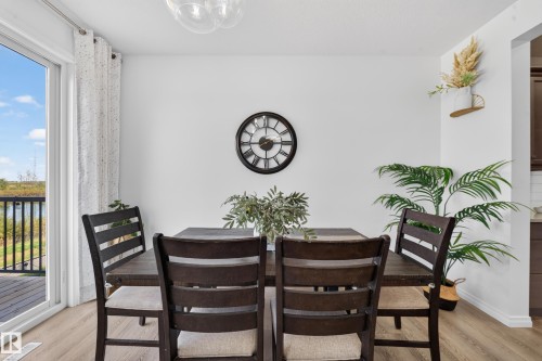 White walls, wood-finish flooring, and a sliding glass door providing natural illumination - 4104 3 Avenue Sw, Edmonton, AB 