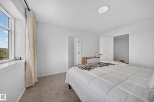 Recessed ceiling lighting, durable carpeting, crisp white walls, and a window with a water feature - 4104 3 Avenue Sw, Edmonton, AB 