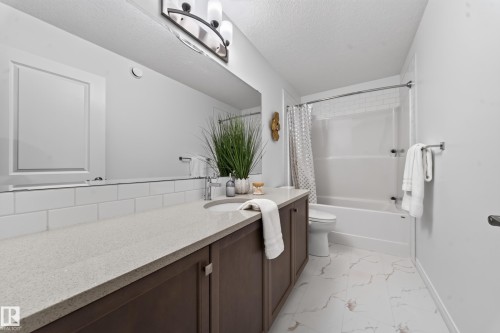 Vanity with light-toned countertop, undermount sink, and dark wood-finish cabinetry - 4104 3 Avenue Sw, Edmonton, AB 
