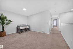 Carpeted room with white walls, recessed lighting, and a solar tube skylight - 