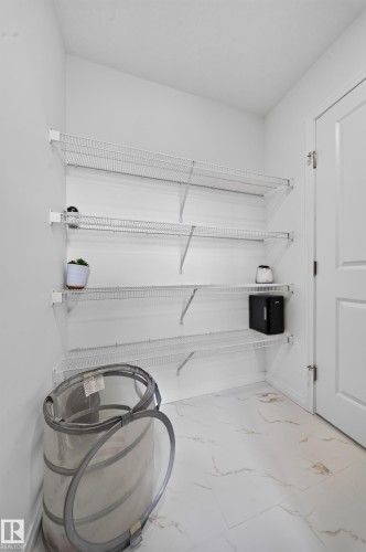White wire shelving system, white interior walls, white paneled door, and tiled flooring - 4104 3 Avenue Sw, Edmonton, AB 