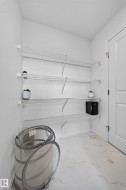 White wire shelving system, white interior walls, white paneled door, and tiled flooring - 