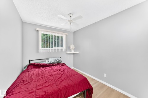 Light-toned wood-finish flooring, ceiling fan, window with vertical blinds, and wall-mounted shelving - 44 Habitat Crescent Nw, Edmonton, AB 