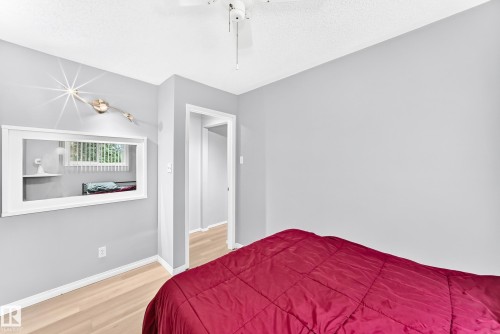 Light-toned wood-finish flooring, white ceiling fan, interior pass-through window, and light gray wall paint - 44 Habitat Crescent Nw, Edmonton, AB 