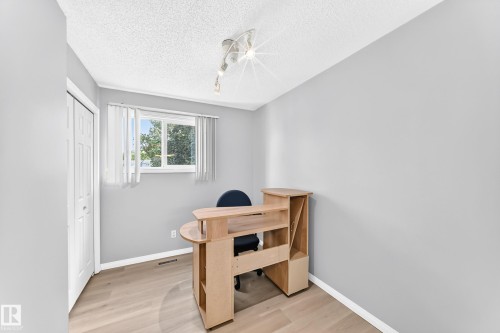 Light gray walls with white trim, wood-finish flooring, a window with vertical blinds, and a bi-fold closet door - 44 Habitat Crescent Nw, Edmonton, AB 