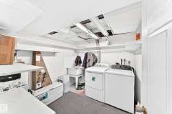 Laundry area featuring a utility sink and extensive wall shelving - 